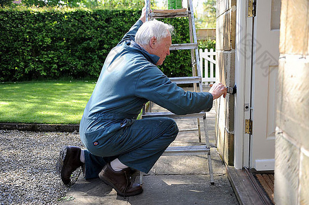 这位75岁的退休老人正在英国约克郡北部为自己家的门廊喷漆