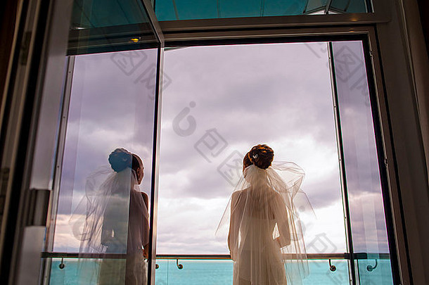 漂亮的新娘站在阳台上。