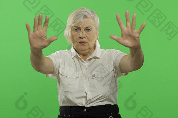 上了年纪的女人显示停止手势漂亮的祖母白色衬衫的地方标志文本浓度关键绿色屏幕背景