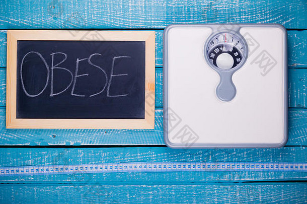 显示浴室秤和黑板上显示肥胖的减肥概念