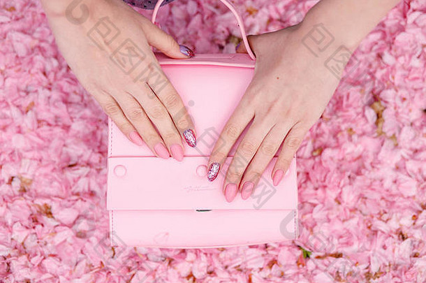 浅粉色背景的时尚手提包。柔和色彩的春夏时尚概念