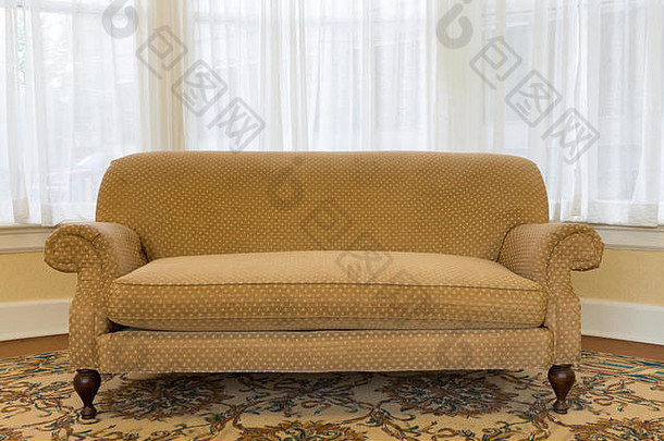 在起居区，用白色窗帘和背景玻璃窗将优雅的棕色沙发家具收拢。