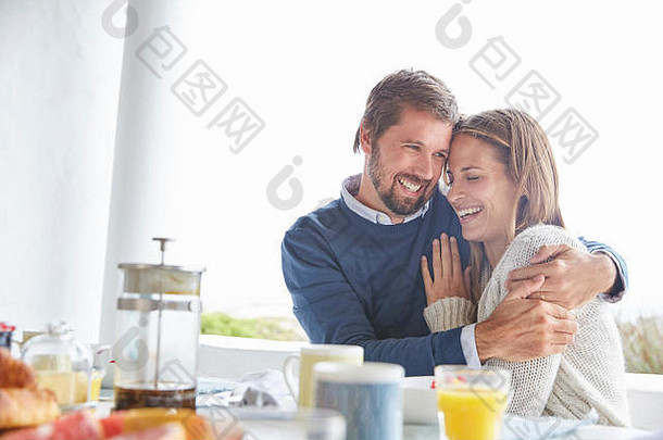 微笑充满深情的夫妇拥抱天井早餐表格