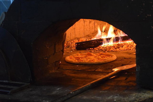 在菲律宾碧瑶市的一家餐厅里，新鲜的意大利原汁原味比萨饼在传统的意大利木火石砖烤箱中制作和烘焙