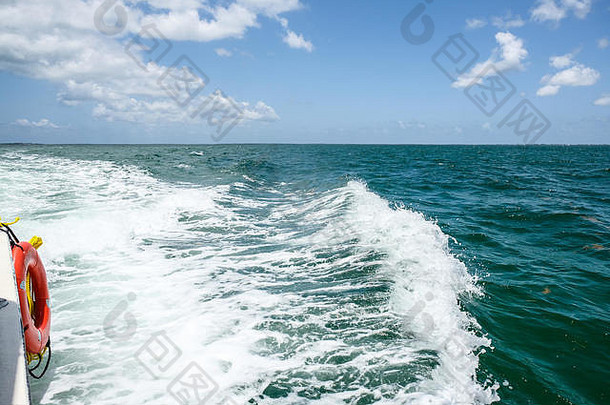 在黄貂鱼城大开曼岛附近的一艘旅游船的末端，热带海洋的波浪