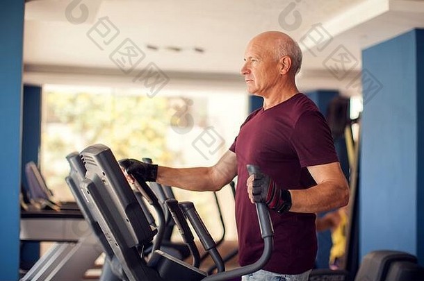 一张秃顶老人在有氧健身区训练的肖像。人、健康和生活方式概念