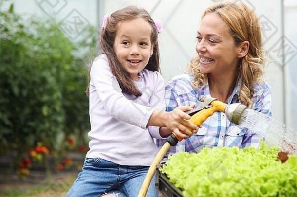美丽快乐的母亲和女儿在农场、花园里工作