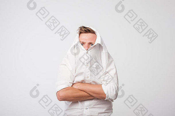 愤怒的白人男子将一件白衬衫套在头上。抑郁者的孤独感。