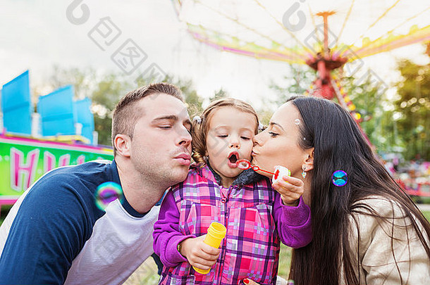 爸爸、妈妈和女儿吹泡泡，一家人在娱乐