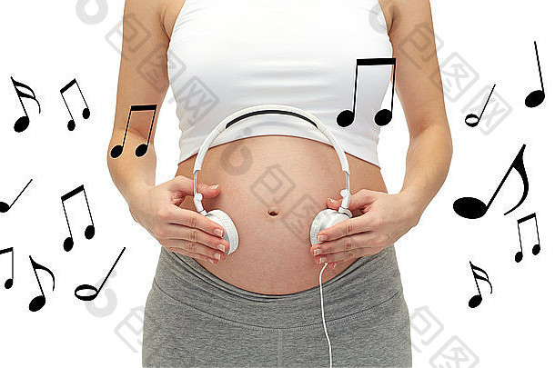 孕妇特写镜头和戴在肚子上的耳机