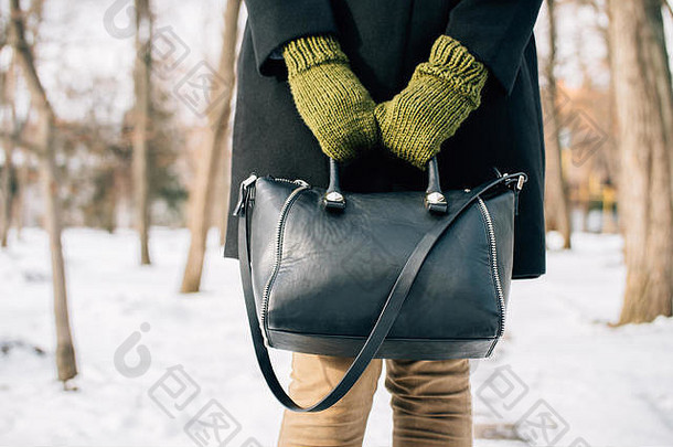冬天，一个穿着外套的女人手<strong>拿钱</strong>包在户外的剪影