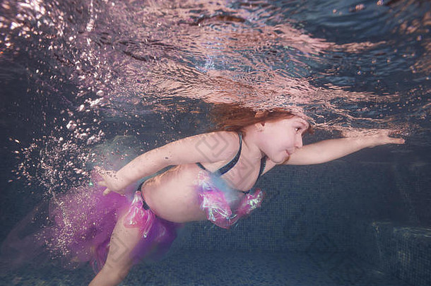 女孩玩水下池浮点数旋转空气泡沫健康的家庭生活方式孩子们水体育活动孩子开发