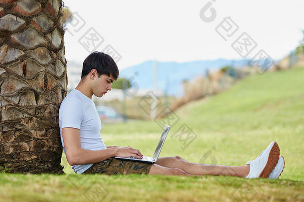 坐在草地上使用笔记本电脑的年轻人的个人简介