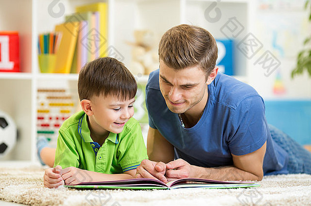 小男孩和爸爸在家的地板上看书