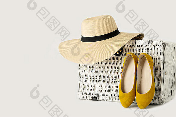 白色柳条手提箱，一顶女帽和黄色的鞋子。