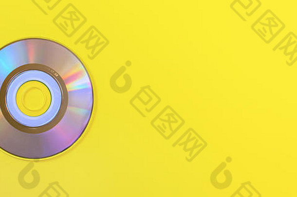 自上而下的视图，小CD闪亮/彩虹面，在黄色板上，右侧有文本空间。