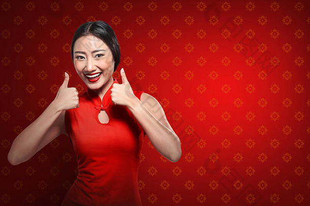 穿旗袍的中国女人竖起大拇指。新年快乐概念