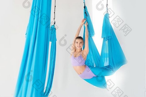 美丽的年轻的女人统一的教练显示体式伸展运动航空飞瑜伽蓝色的吊床白色<strong>类</strong>