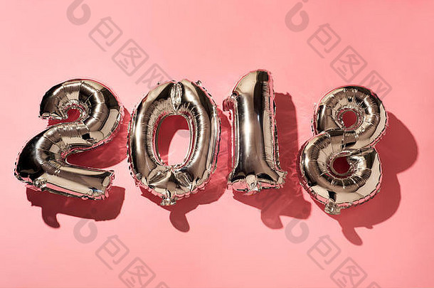 一些银色的数字形状的气球在粉红色背景下形成2018年的数字，作为新年