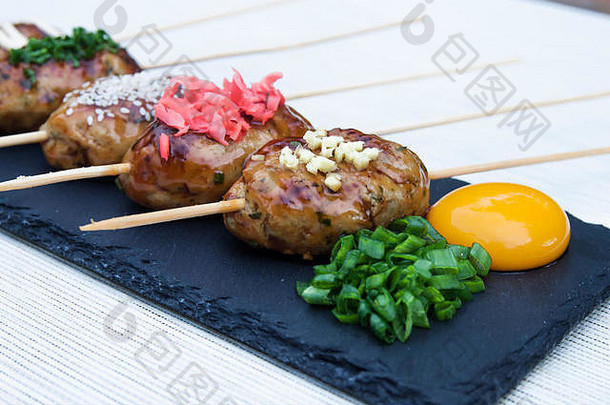 Tsukune-日本烤鸡牦牛肉丸，配辣椒酱、辣椒片、胡椒粉和柠檬角。