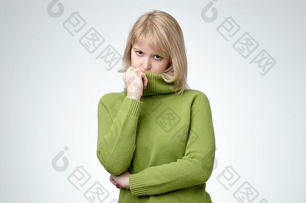 心烦意乱抑郁金发女郎年轻的女人穿绿色毛衣伤心不开心