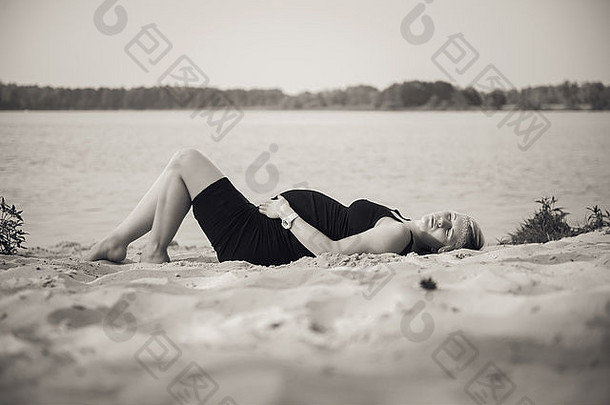 海滩上一位年轻美丽的孕妇的肖像。
