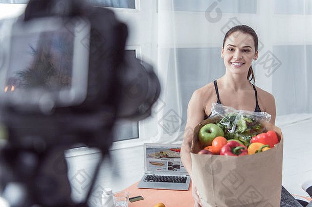 快乐的女人展示着一个装满蔬菜的袋子