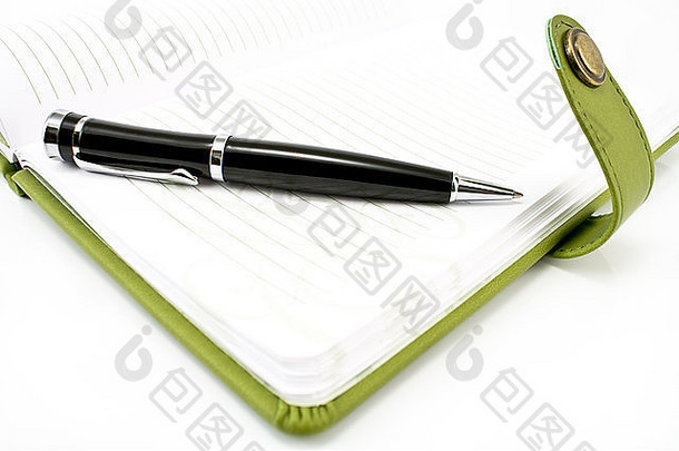 笔和绿色的笔记本在白色上