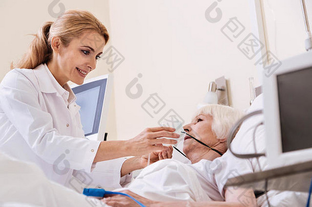 整洁的主管女人把氧气面具病人