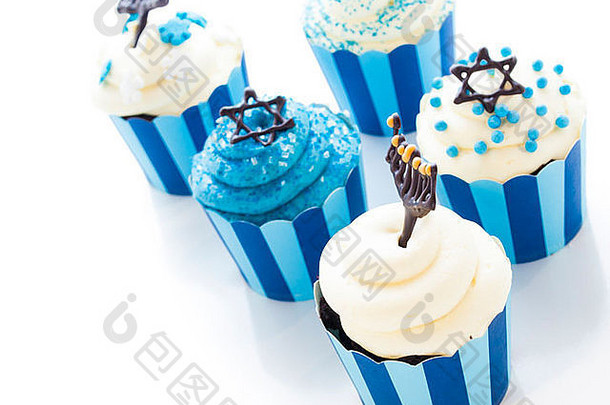 光明节用白色和蓝色糖衣装饰的美味纸杯蛋糕。