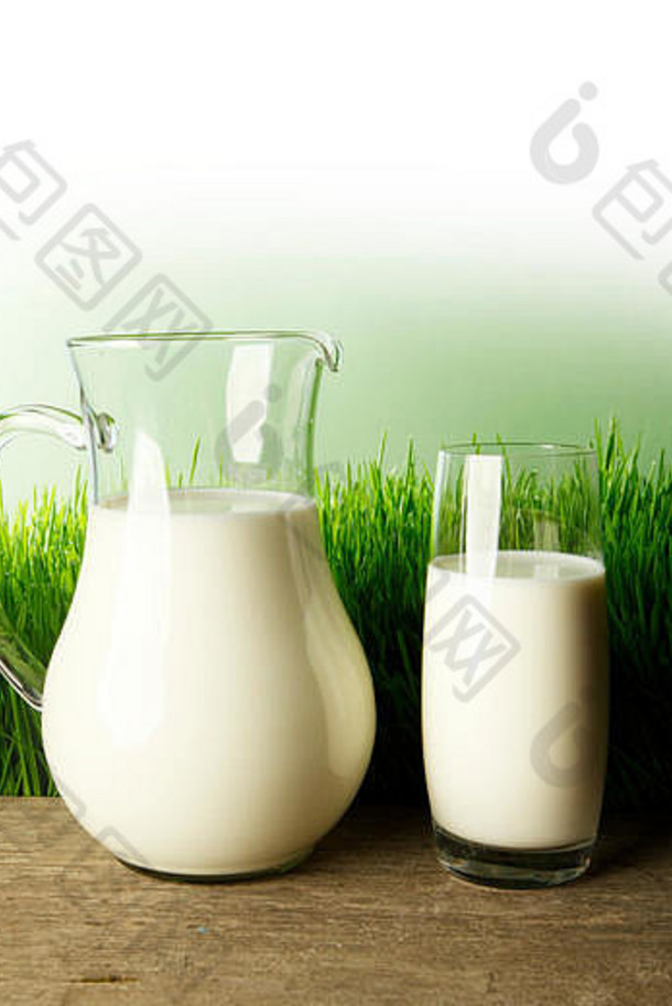 一杯牛奶和一罐洋甘菊放在草地上