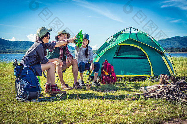 集团年轻的亚洲朋友享受野餐聚会，派对湖野营背包椅子年轻的人敬酒欢呼瓶啤酒peopl