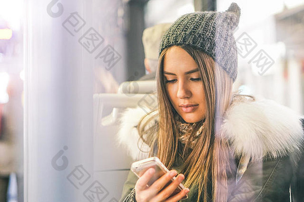 <strong>坐</strong>在<strong>公交</strong>车上使用智能手机的年轻女子——漂亮女孩用手机连接社交网络