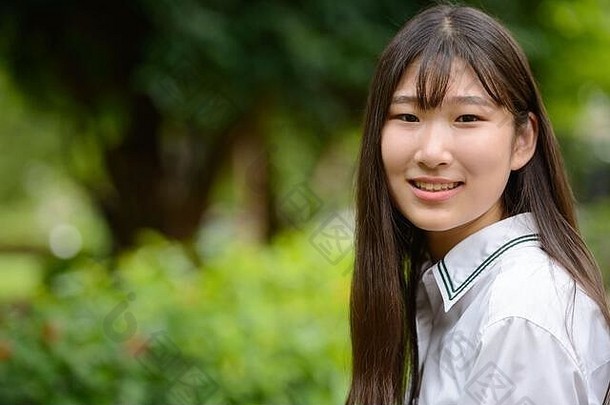 快乐年轻的美丽的亚洲十几岁的女孩公园