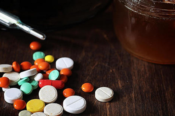 木桌上的药物和药丸。<strong>预防感冒</strong>的各种方法