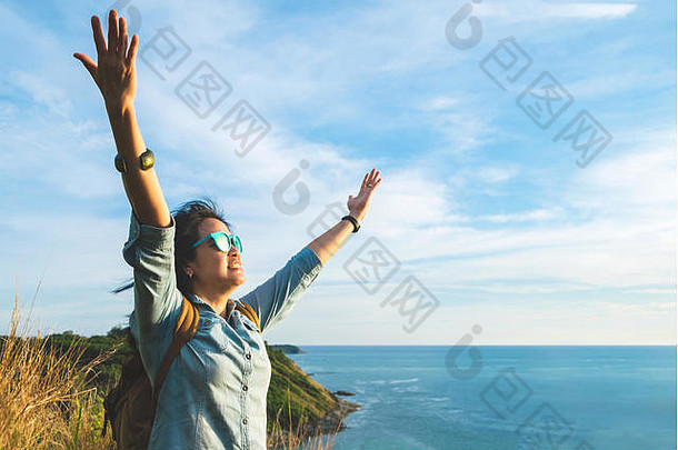 快乐年轻的旅行者女人提高了手臂天空享受美丽的自然前山海视图<strong>自由旅<strong>游</strong>热背包客概念
