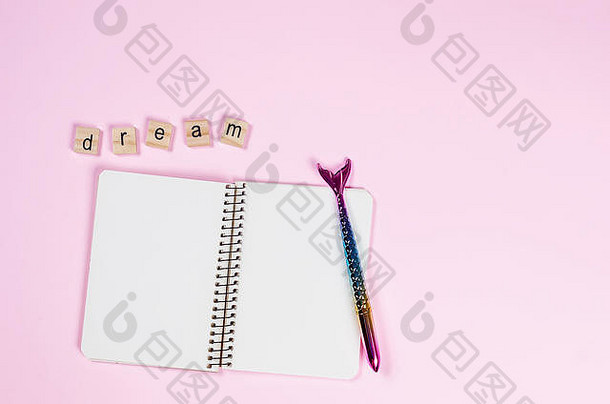 笔记本和时髦的美人鱼尾巴形状的钢笔，粉红色背景上的木制字母上刻<strong>有</strong>“<strong>梦</strong>想”，概念为“大<strong>梦</strong>”