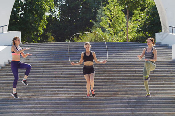 三个运动女孩跳<strong>上台</strong>阶，其中一个跳上绳子