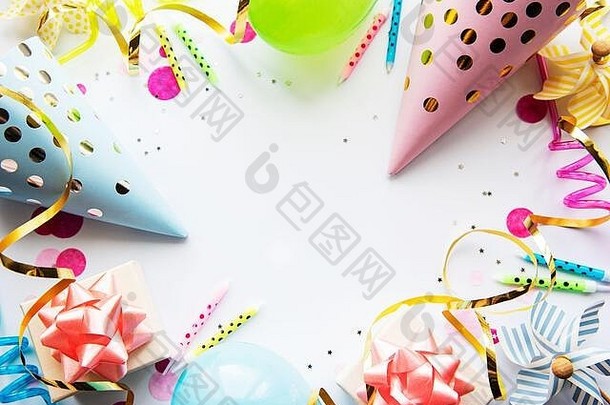 生日快乐或派对背景。白色背景上平铺着生日气球、五彩纸屑和丝带。顶视图。空间。