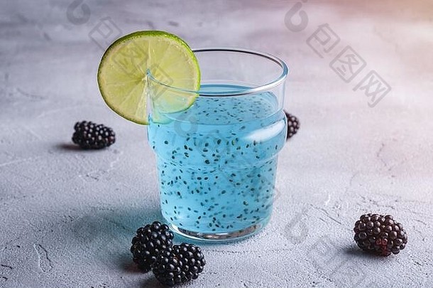 美味的蓝色的彩色的鸡尾酒喝罗勒传讲种子柑橘类石灰片黑莓<strong>玻璃</strong>健康的夏天饮料石头混凝土背景