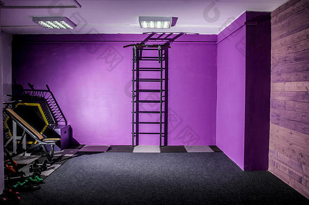 空的健身房健身大厅，墙上有运动器材和梯子