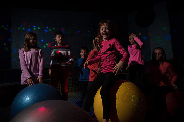 一群快乐的孩子快乐地在孩子们的霓虹灯迪斯科派对上度过时光