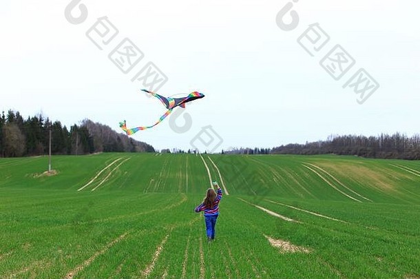 春天，小女孩在田野里放风筝。