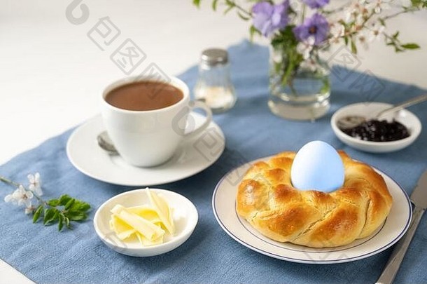 打褶的面包巢复活节蛋咖啡黄油小时花蓝色的餐巾白色表格节日假期breakfeast单