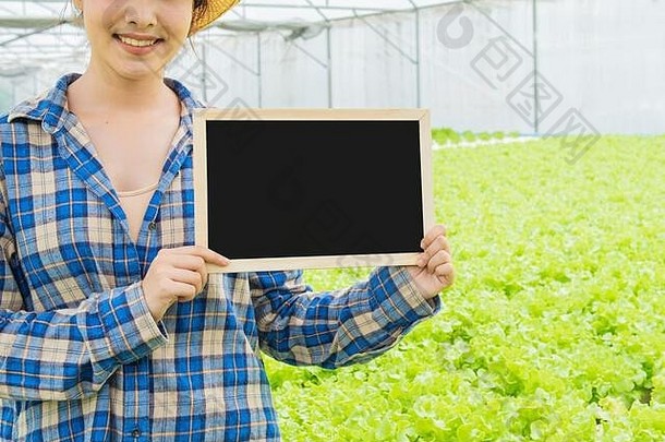 空小黑色的董事会绿色蔬菜内力的有机农场部分亚洲男人。女人站绿色生菜农场背景
