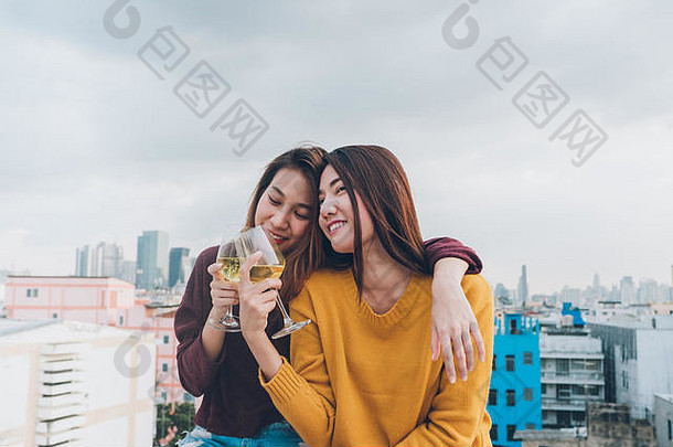 快乐亚洲女孩朋友享受笑快乐的闪闪发光的酒玻璃屋顶聚会，派对假期庆祝活动节日teeage生活方式自由有趣的