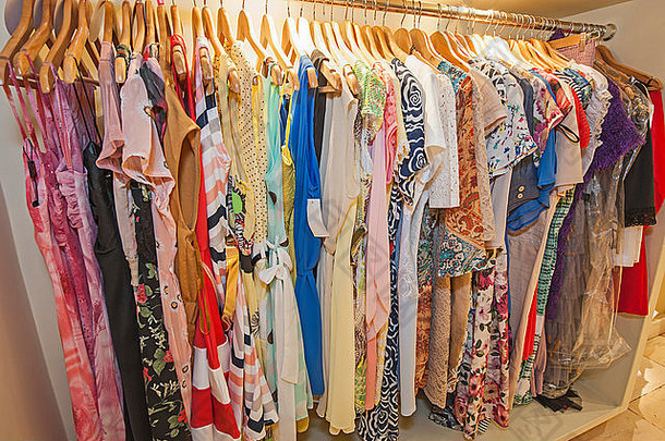 各种色彩斑斓的女人的夏天时尚衣服挂铁路零售商店