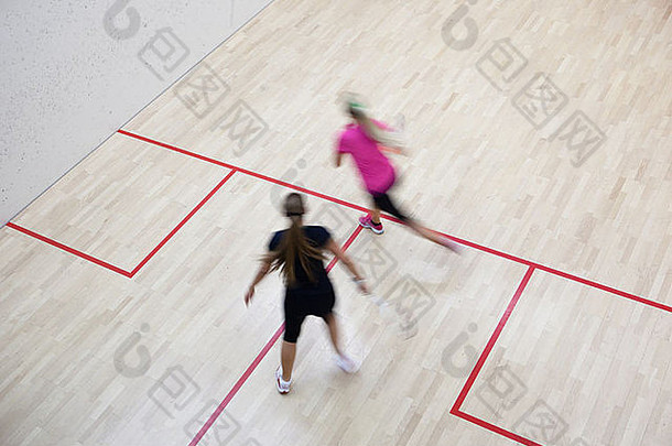 两名女子壁球运动员在壁球场上快速动作（运动模糊图像；彩调图像）