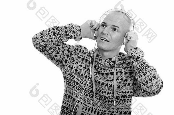 工作室拍摄的年轻快乐的秃头男人一边听音乐一边思考