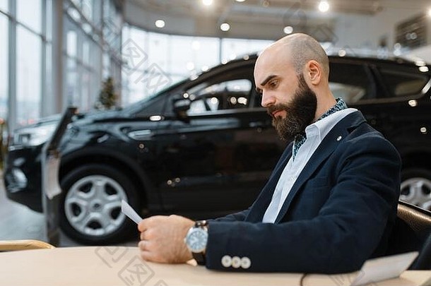 男子看新车、汽车经销商的价格
